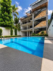 a swimming pool in front of a building at Villa 777 in Kadawata