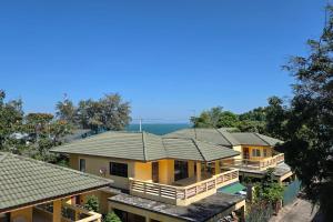 a row of houses with the ocean in the background at Bacchus Home Resort Pranburi in Ban Pak Nam Pran