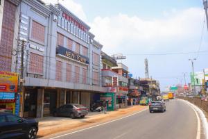 a city street with cars parked on the side of the road at The Hotel Chettungal in Angamaly