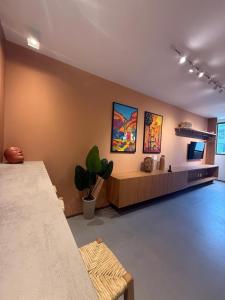 a living room with a couch and paintings on the wall at Beira Mar Japaratinga Brisa in Japaratinga
