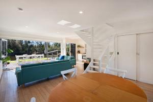a living room with a green couch and a table at The River Retreat in Sussex Inlet