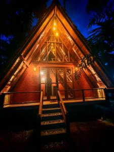 a cabin with stairs leading to the front door at night at Paddy field Whispering wind Cabin in Ahangama Nakanda