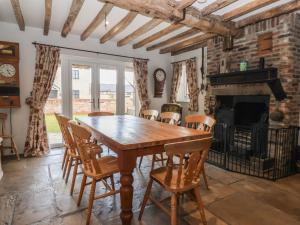 a dining room with a table and chairs and a fireplace at Redwoods in Beverley