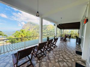 a balcony with chairs and a view of a mountain at Green Village in Ella
