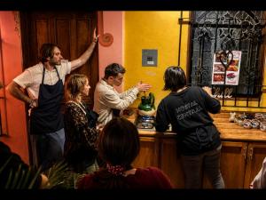 a group of people standing around a bar at Hostal Central Oaxaca in Oaxaca City