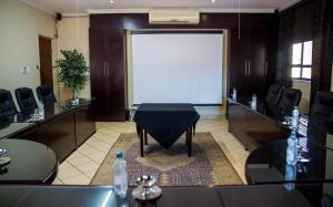 a meeting room with a large white screen in the middle at Rustenburg Boutique Hotel in Rustenburg +81 photos