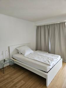 a white bed in a room with a window at Apartment 416 mit Pool in Lahnstein