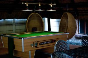 a pool table in a room with two chairs at Rustenburg Boutique Hotel in Rustenburg