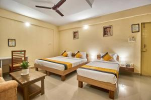 a hotel room with two beds and a couch at Itsy Hotels Emirates Suites - Near RMZ EcoWorld, Bellandur in Bangalore +21 photos
