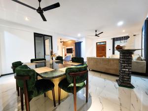 a dining room and living room with a table and chairs at Villa 777 in Kadawata