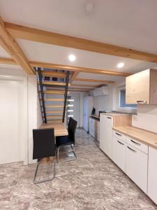 a kitchen with a wooden table and some chairs at Sun House Luka in Radmirje +15 photos