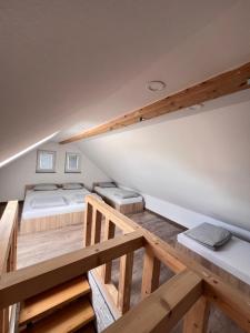 a loft bedroom with two beds and wooden floors at Sun House Luka in Radmirje