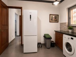 a kitchen with a refrigerator and a washing machine at KFC Homes in Yaoundé