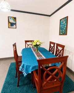 a dining room table with a vase of flowers on it at KFC Homes in Yaoundé +2 photos