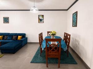 a living room with a table and a blue couch at KFC Homes in Yaoundé