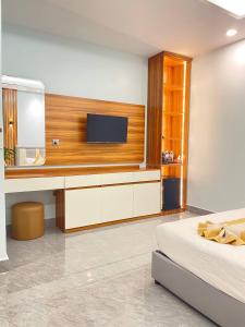 a bedroom with a tv on a wall and a bed at Khemra Kampot Hotel in Kampot in Kampot