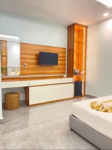 a bedroom with a tv and a bed and a mirror at Khemra Kampot Hotel in Kampot in Kampot +13 photos