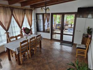 a dining room with a white table and chairs at Casa Deea in Căpăţîneni-Pămînteni