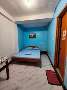 a bedroom with a bed in a blue room at Aunora Standard Room in San Miguel +30 photos