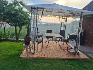 a gazebo with a table and chairs on a deck at Apartamenty Pienińska Aura in Czorsztyn
