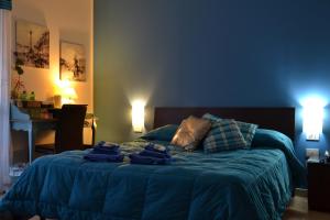 ein Schlafzimmer mit einem blauen Bett und Handtüchern darauf in der Unterkunft B&B Due Fontane in Caltanissetta
