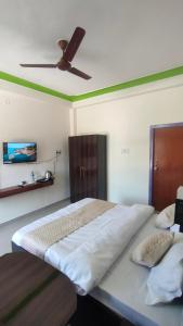 a bedroom with a large bed with a ceiling fan at Hotel Park Royal in Pithorāgarh