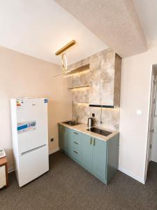 a kitchen with a sink and a refrigerator at Margad Hotel in Ulaanbaatar