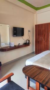 a bedroom with a bed and a flat screen tv at Hotel Park Royal in Pithorāgarh