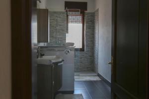 a small bathroom with a sink and a window at Il Rovo Rooms in Porto Torres
