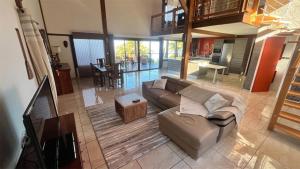 a living room with a couch and a table at Villa TheOceane in Les Avirons