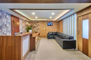 a living room with a black leather couch in a room at Itsy Hotels Emirates Suites - Near RMZ EcoWorld, Bellandur in Bangalore
