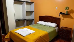 a bedroom with a bed with towels on it at Hotel Grant Ruiseñor in Chambo