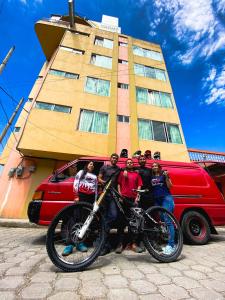 a group of people posing with a motorcycle in front of a building at Hotel Grant Ruiseñor in Chambo