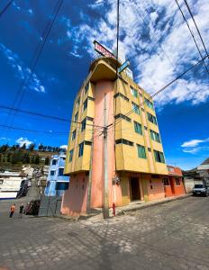 a building with a sign on the top of it at Hotel Grant Ruiseñor in Chambo