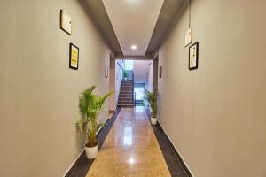 a hallway with potted plants and stairs in a building at Itsy Hotels Emirates Suites - Near RMZ EcoWorld, Bellandur in Bangalore