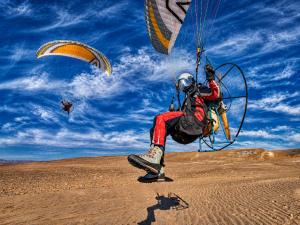 a man flying a parachute in the desert at Limra Desert Camp With Swimming pool in Jaisalmer