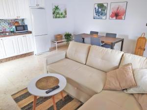 a living room with a white couch and a table at Chalet La Caballa Playa la Barrosa in Chiclana de la Frontera