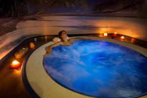 a man in a bath tub with blue water at Il Piccolo Castello in Monteriggioni