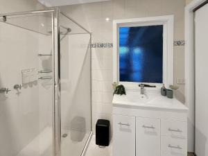 a white bathroom with a sink and a shower at Gables on Malcolm in Mansfield +14 photos