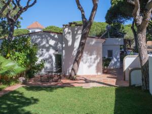 a patio with a table and a bench in a yard at Chalet La Caballa Playa la Barrosa in Chiclana de la Frontera