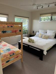 a bedroom with two bunk beds and two windows at Marcail Views Lakes Entrance in Lakes Entrance