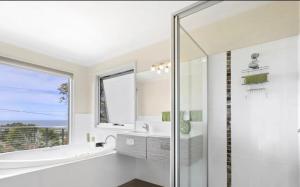 a white bathroom with a tub and a sink at Marcail Views Lakes Entrance in Lakes Entrance +29 photos