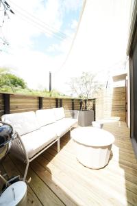 a patio with white furniture on a wooden deck at 紀の川みんと静 in Kinokawa
