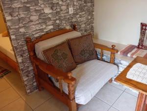 a chair in a room with a stone wall at Villa Vitta picola casa in Nafpaktos