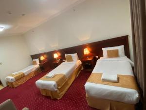 a room with three beds in a hotel room at فندق ريماس العنود in Mecca +2 photos