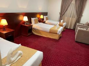 a hotel room with two beds and a couch at فندق ريماس العنود in Mecca