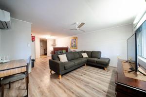 a living room with a couch and a table at Comfy Kirwan Getaway in Ross River +9 photos
