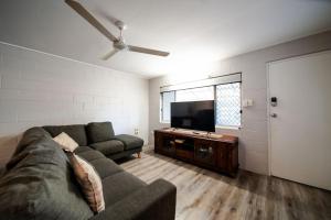 a living room with a couch and a flat screen tv at Comfy Kirwan Getaway in Ross River