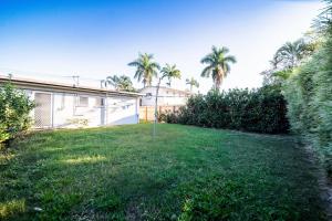 a yard with a house and palm trees at Comfy Kirwan Getaway in Ross River