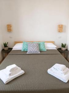 a bed with two towels sitting on top of it at Marconi 306 in Quartu Sant'Elena